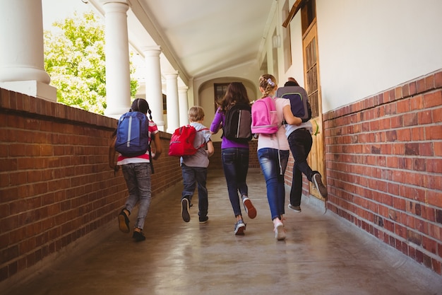 Foto niños de la escuela corriendo en el pasillo de la escuela