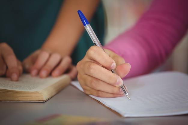 Niños de la escuela haciendo la tarea en la biblioteca