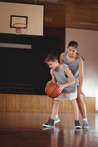 Niños de la escuela jugando baloncesto