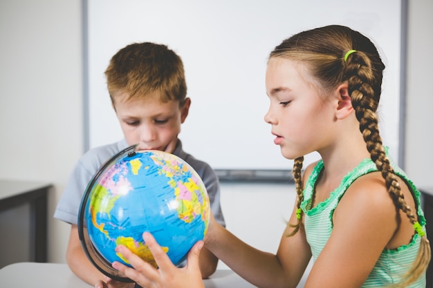 Niños de la escuela mirando el globo en el aula