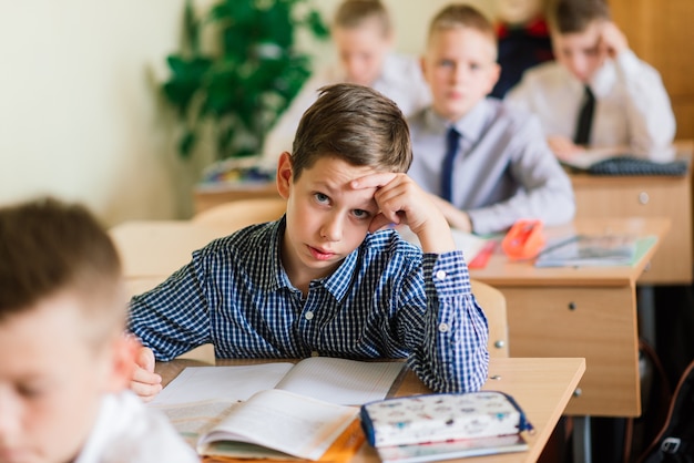 Niños de escuela primaria escribiendo en libros en el aula