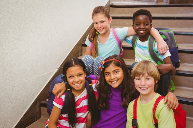 Niños de la escuela sentados en las escaleras en la escuela