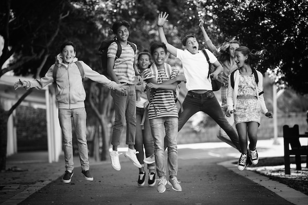 Niños de la escuela sonrientes divirtiéndose en la carretera en el campus