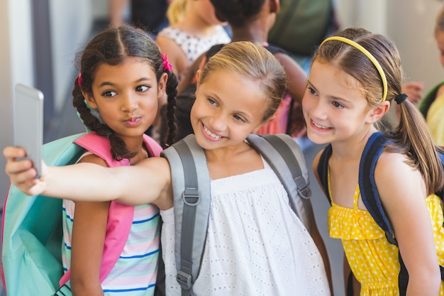 Niños de la escuela tomando selfie en teléfono móvil