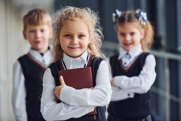 Niños de la escuela en uniforme junto con libros en el corredor Concepción de la educación