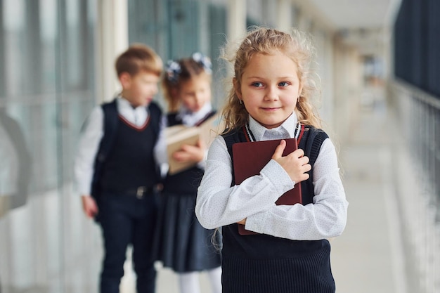 Niños de la escuela en uniforme junto con libros en el corredor Concepción de la educación