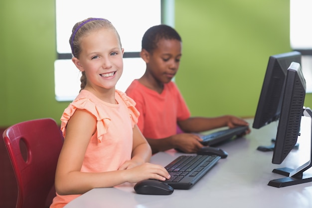 Niños de la escuela usando la computadora en el aula