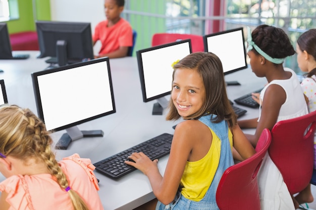 Niños de la escuela usando la computadora en el aula