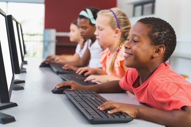 Niños de la escuela usando la computadora en el aula