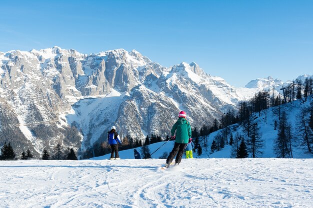 Niños esquiando a gran velocidad cuesta abajo contra las montañas. Concepto personas, deporte