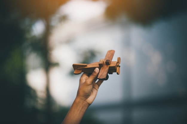 Los niños están felices de jugar al avión con cielo azul en verano. Y en el bosque de sombra.