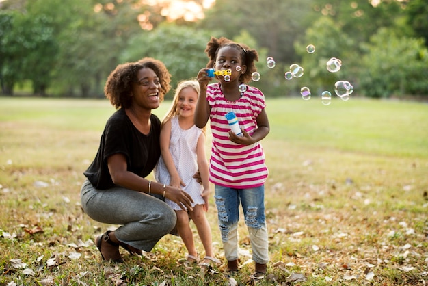 Los niños están jugando burbujas en un parque