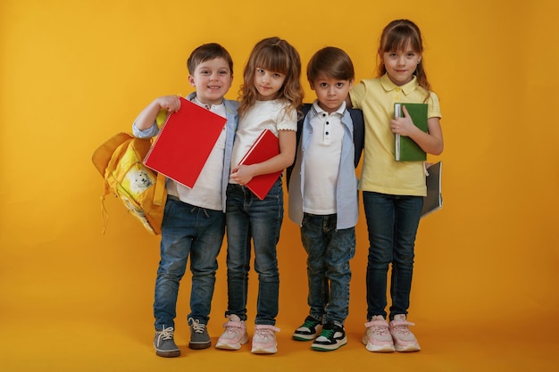 Los niños están juntos contra un fondo amarillo
