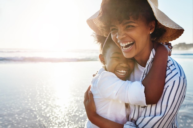 Niños de familia y playa con una madre y una hija riéndose o bromeando juntas en el océano o el mar Aman a los niños y la costa con una mujer negra y una niña divirtiéndose mientras se unen por el agua en la naturaleza