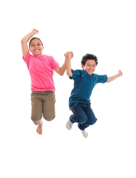 Niños felices activos saltando con alegría aislado sobre fondo blanco.