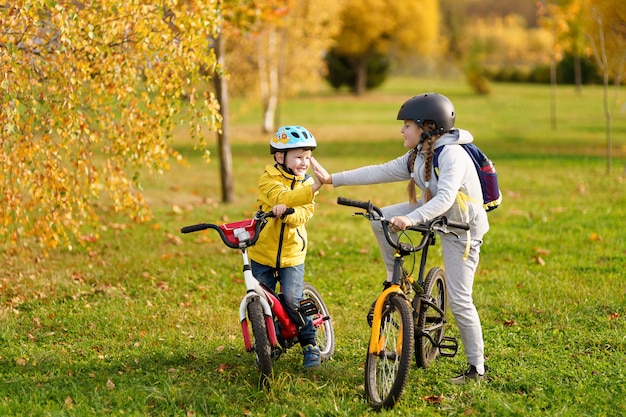 Niños felices con bicicletas al aire libre en ropa brillante con bicicletas