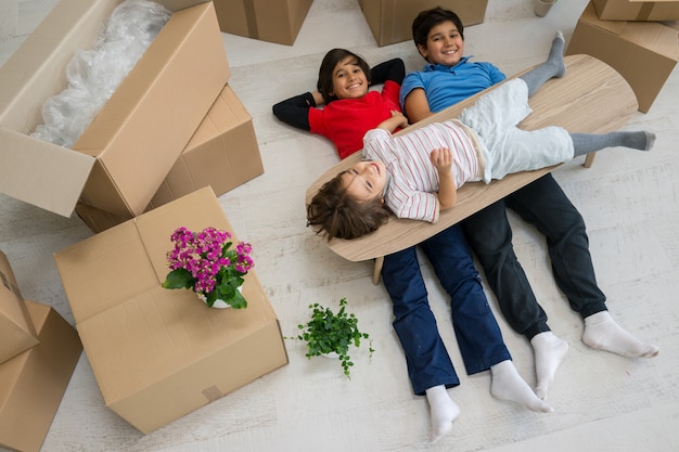 Niños felices con cajas en casa moderna nueva
