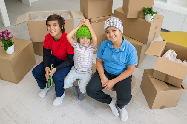 Niños felices con cajas en casa moderna nueva