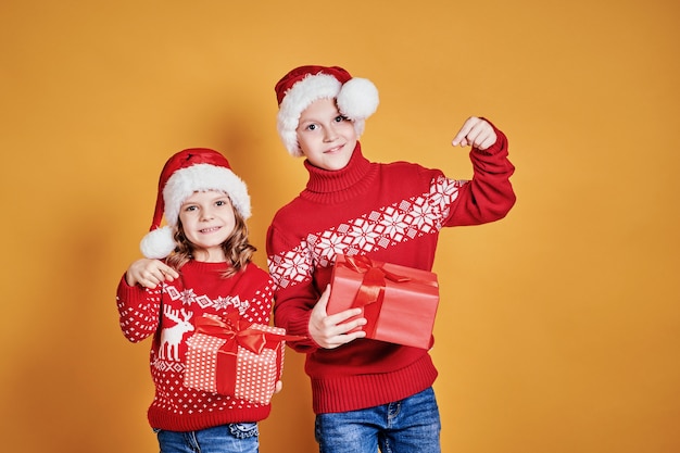 Niños felices con cajas de regalo rojo