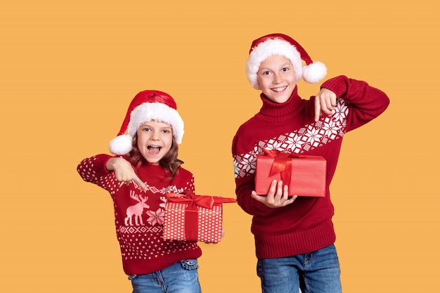 Niños felices con cajas de regalo rojo