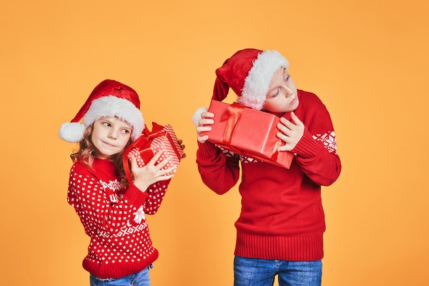 Niños felices con cajas de regalo rojo