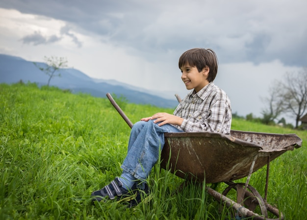 Niños felices en campo jugando con carro