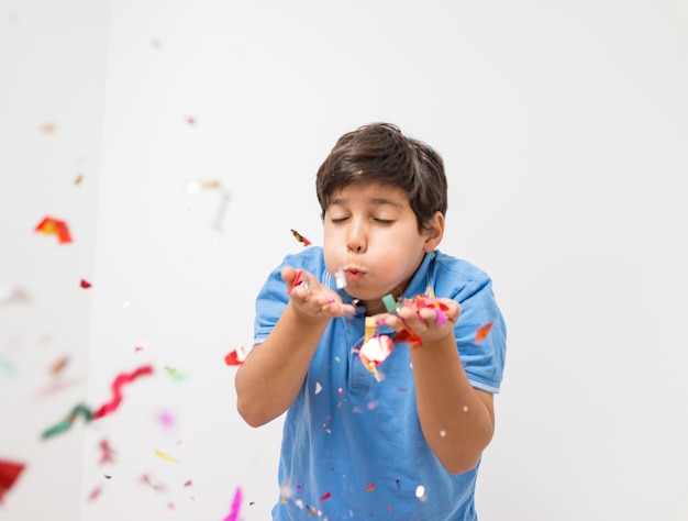 Niños felices celebrando la fiesta con soplar confeti