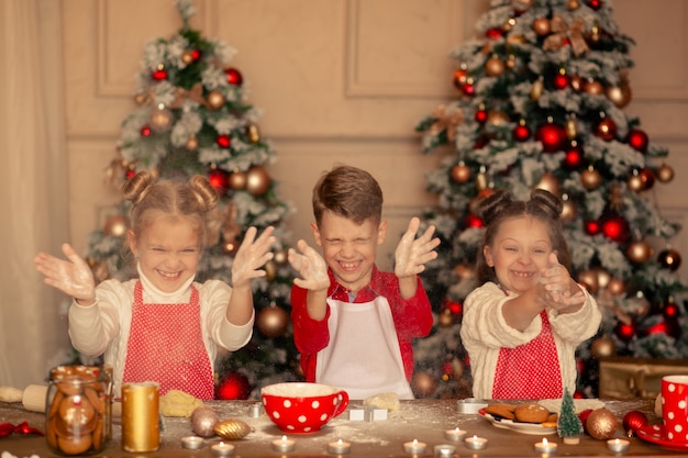 Niños felices cocinando galletas de Navidad