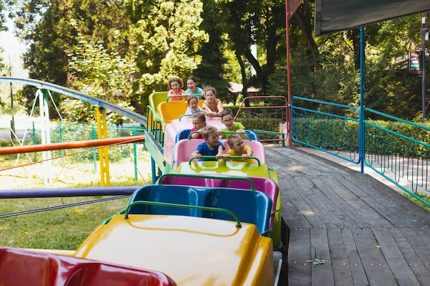 Los niños felices descansan en el parque de atracciones.