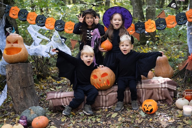 niños felices en disfraces de halloween divirtiéndose en decoraciones de halloween al aire libre