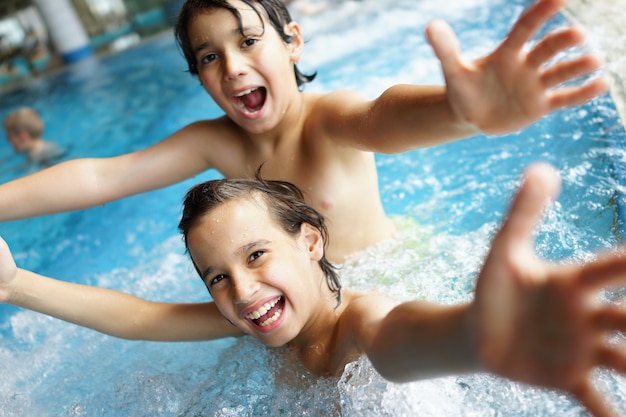 Niños felices disfrutando en la piscina de verano