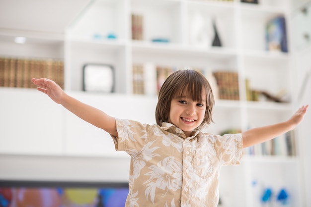 Niños felices divirtiéndose y posando en el nuevo hogar moderno