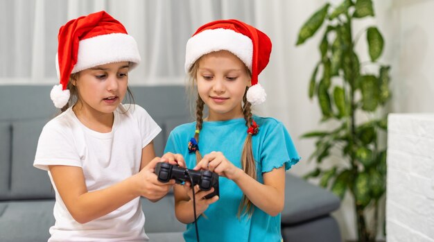 Niños felices, dos niñas con un joystick jugando un videojuego