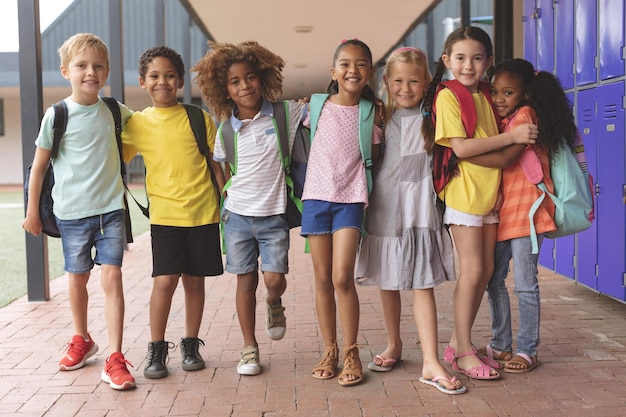 Niños felices de la escuela de pie en el pasillo