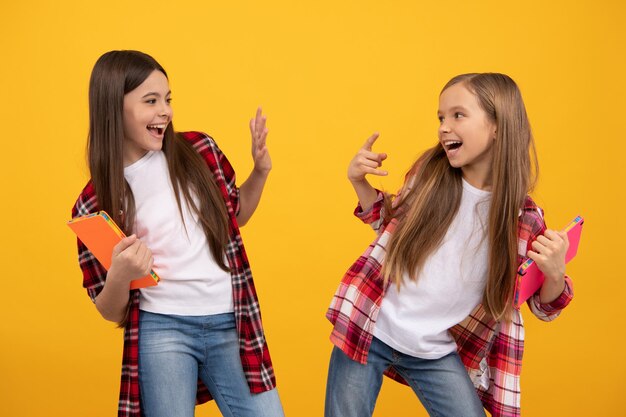 Niños felices felices en camisa a cuadros casual con cuadernos divertidos