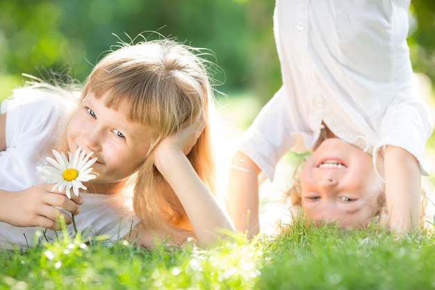 Niños felices con flores jugando en el parque de primavera