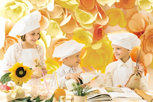 Niños felices en forma de chef para preparar deliciosas comidas