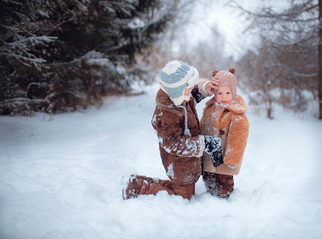 Niños felices jugando en la nieve en invierno