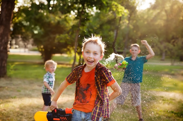 Niños felices jugando con pistolas de agua