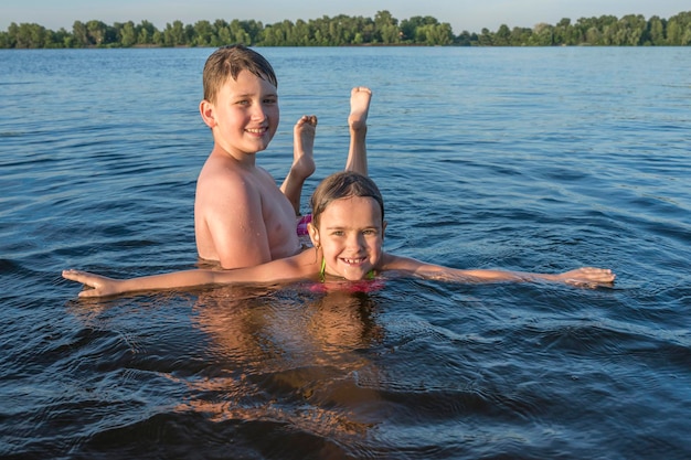 Niños felices jugando en el río Vacaciones de verano en la playa