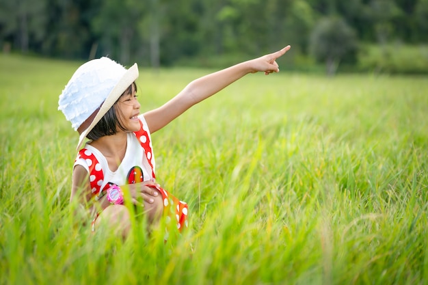 Niños felices jugando y sonríen en los pastizales de la naturaleza