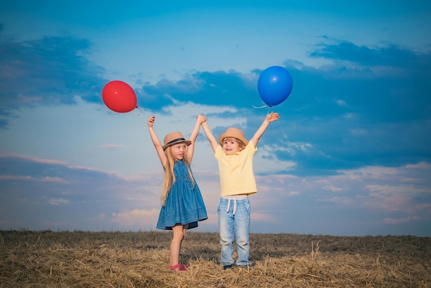 Niños felices jugando en verano, niño y niña disfrutan de la vida y la naturaleza, niña y niño disfrutan