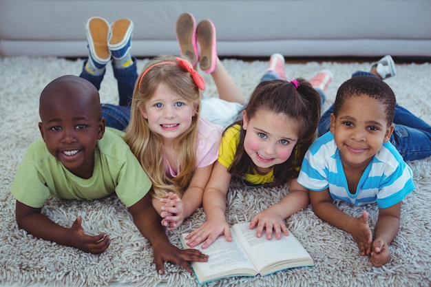 Niños felices leyendo un libro juntos