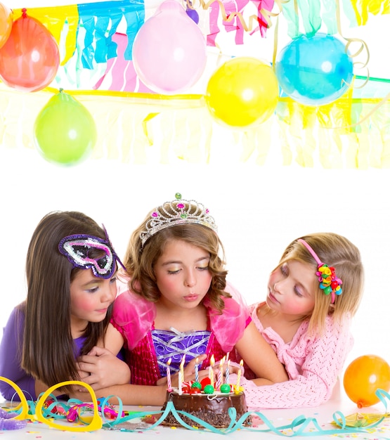 Foto niños felices niñas soplando cumpleaños fiesta pastel