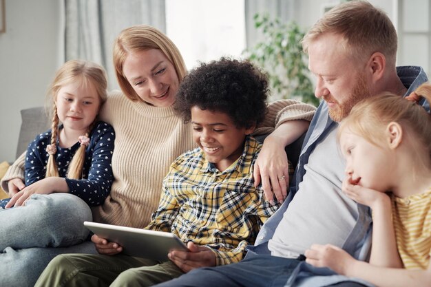 Niños felices con padres adoptivos en casa