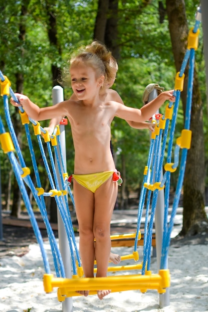 Niños felices en el patio de recreo, niños en la naturaleza en verano. Vacaciones activas y lúdicas con niños.