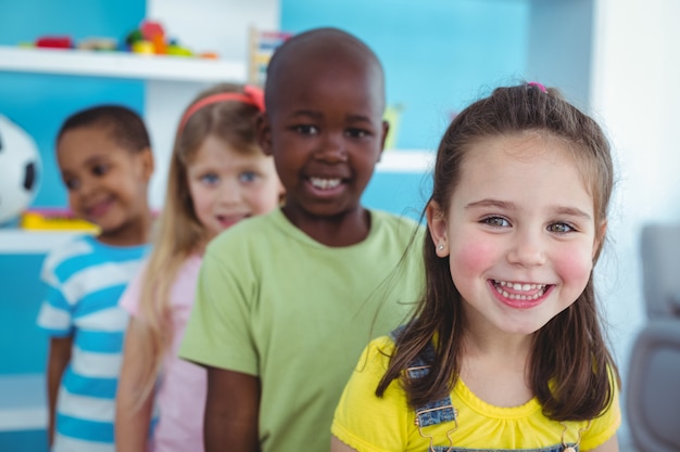 Niños felices de pie en una línea