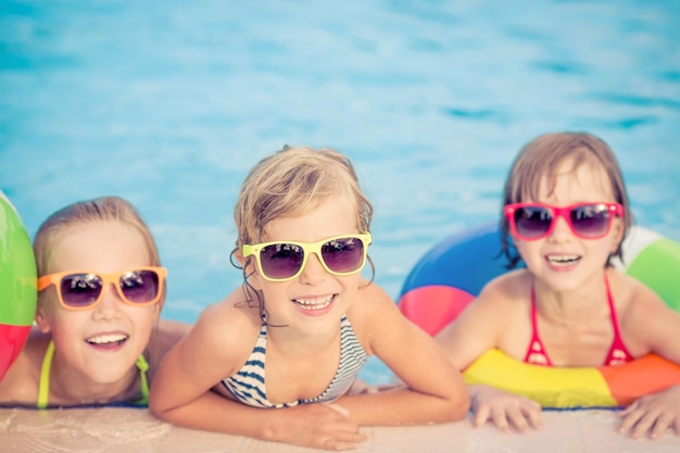 Niños felices en la piscina Niños divertidos jugando al aire libre Concepto de vacaciones de verano