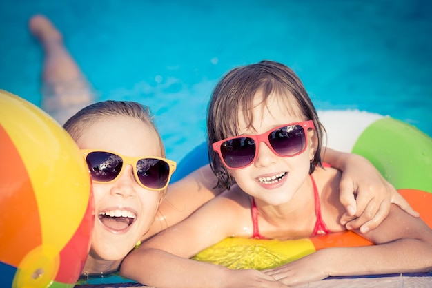Niños felices en la piscina Niños divertidos jugando al aire libre Concepto de vacaciones de verano