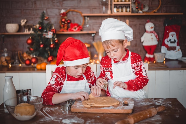 Niños felices preparan galletas festivas de Navidad en la cocina de la casa en Nochebuena feliz Navidad y feliz Año Nuevo vacaciones familiares